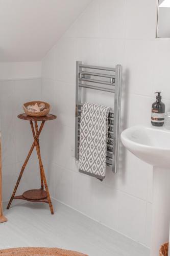 a bathroom with a towel rack next to a sink at East Street Beach House - luxury living by the sea in Ryde