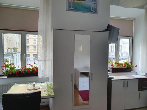 a room with a desk and a table and some windows at Apartments Fazarinc with parking, wellness and city store in the center of Celje in Celje