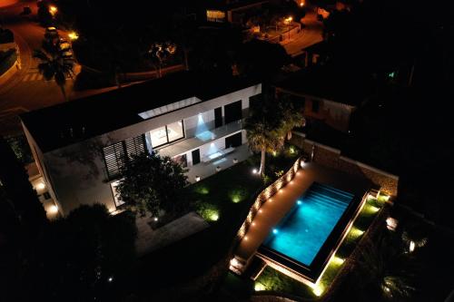 an overhead view of a building with a swimming pool at night at Splendide Villa les pieds dans l'eau dans la baie de Mahon in Es Castell