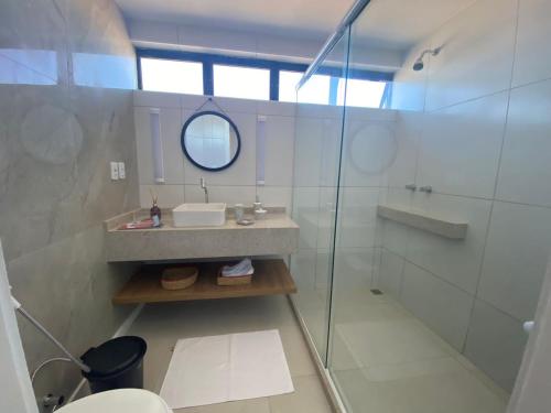 a bathroom with a sink and a glass shower at Janelas de Sol 400 in Fortaleza