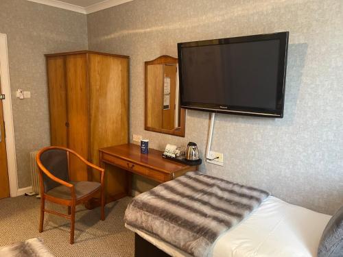 a hotel room with a television and a bed at West Park Hotel in Clydebank