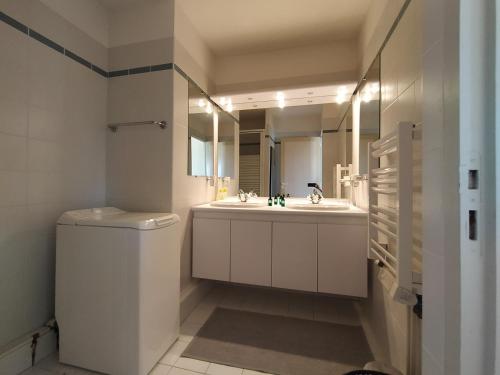 uma casa de banho com um lavatório, um WC e um espelho. em Ursuia Zazpi Au coeur du Golf d'Arcangues em Arcangues