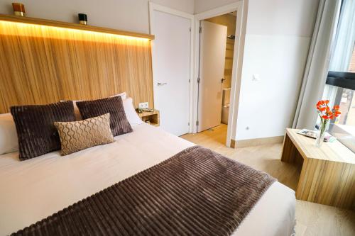 a bedroom with a large bed and a vase of flowers at Studios Cielo Madrid in Madrid