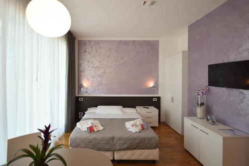 Hotel Mantova Residence في مانتوفا: غرفة نوم بسرير وجدار ارجواني