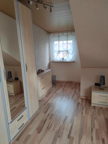 an empty room with a window and a wooden floor at Privatzimmer Guhl in Munster im Heidekreis