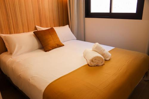 a bed with two towels sitting on top of it at Studios Cielo Madrid in Madrid