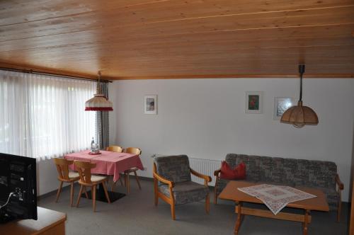 a living room with a table and a couch at Hotel Landhaus Schmid in Fischen