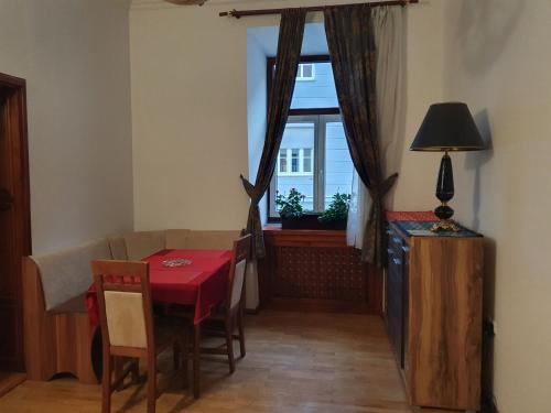 a dining room with a red table and a window at Apartments Fazarinc with parking, wellness and city store in the center of Celje in Celje