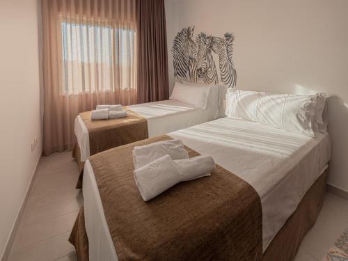 a hotel room with two beds with towels on them at Las Cebras Apartamentos Turísticos in Benicarló