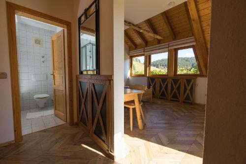two views of a bathroom with a toilet and a sink at Berghotel und Restaurant Kräuter Chalet in Furtwangen