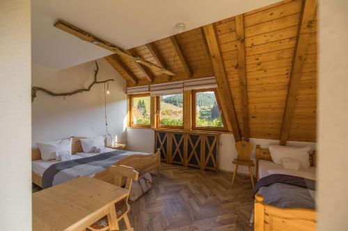 a room with two beds and a table in it at Berghotel und Restaurant Kräuter Chalet in Furtwangen