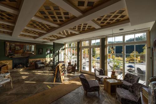 a living room filled with furniture and windows at Berghotel und Restaurant Kräuter Chalet in Furtwangen