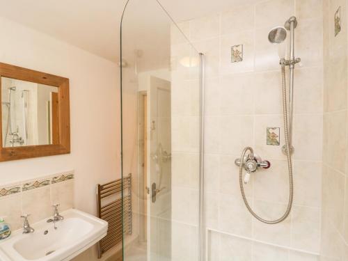 uma casa de banho com um chuveiro e um lavatório. em Beckfold Cottage em Broughton in Furness