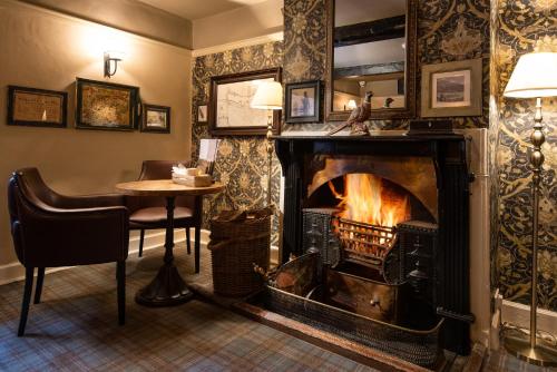 a living room with a fire place and a fireplace at The Pheasant Inn - The Inn Collection Group in Bassenthwaite