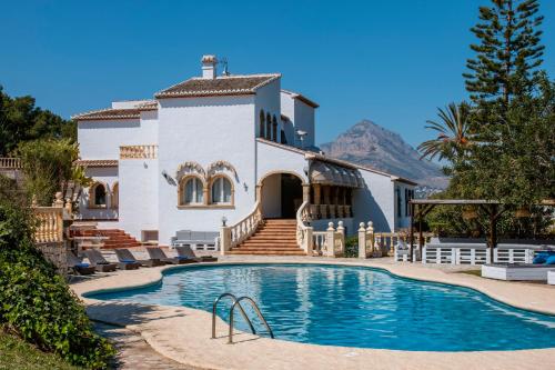 a villa with a swimming pool in front of a house at Adsubia 20 in Jávea