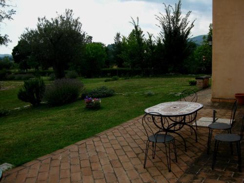 a patio with a table and chairs in a yard at Santa Maria del Gallo in Apiro