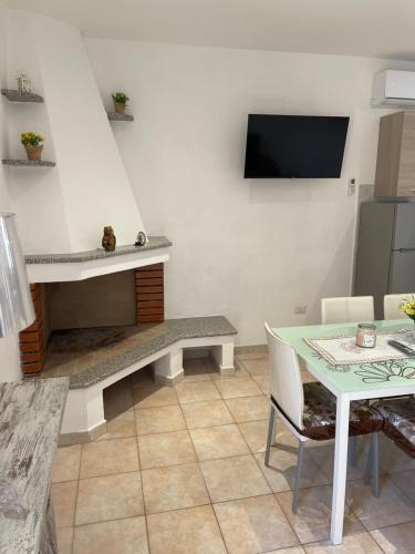 a living room with a table and a tv at Casa Bettina la Maddalena in La Maddalena