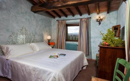 una camera con un letto bianco e una finestra di Villa Vignola a Montaione