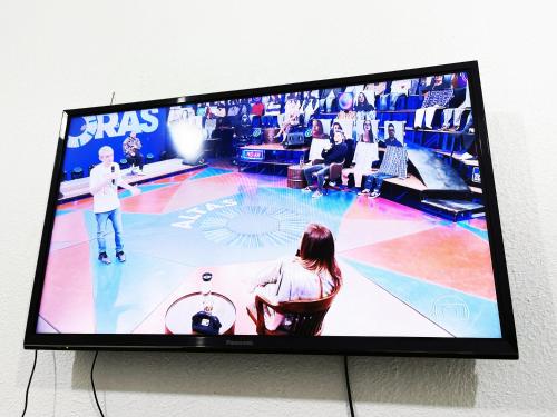 une télévision à écran plat suspendue sur un mur avec un jeu de basket-ball. dans l'établissement Aeroporto House 4, à Macapá
