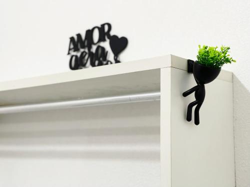 a white shelf with a plant on top of it at Aeroporto House 4 in Macapá