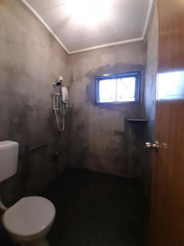 bagno con servizi igienici e finestra. di Holiday Villa Famosa a Malacca