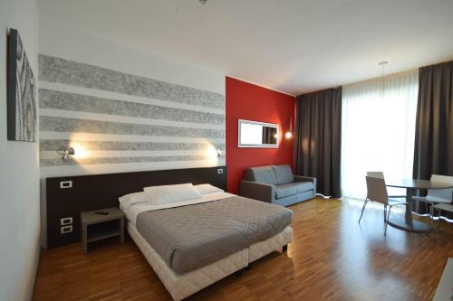 a bedroom with a bed and a red wall at Hotel Mantova Residence in Mantova