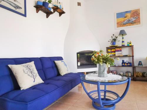 a blue couch in a living room with a table at Caseta de pescadors a les cales de Colera, 2ª linea de mar in Colera