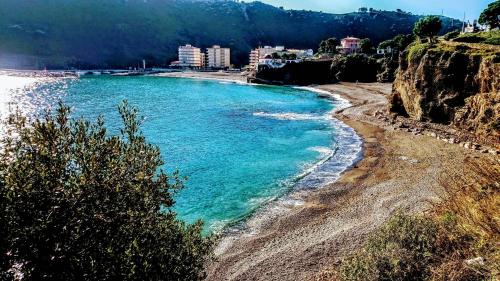 a beach with turquoise water and buildings in the background at Caseta de pescadors a les cales de Colera, 2ª linea de mar in Colera