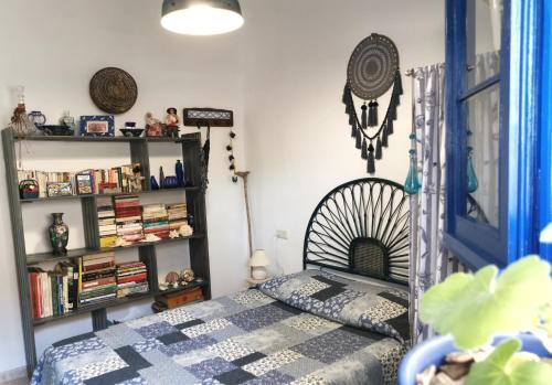 a bedroom with a bed and a book shelf at Caseta de pescadors a les cales de Colera, 2ª linea de mar in Colera