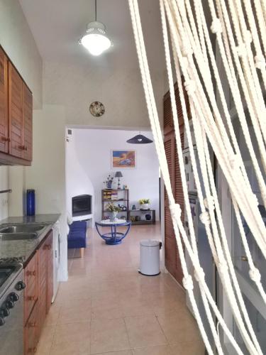 a kitchen with white walls and wooden cabinets at Caseta de pescadors a les cales de Colera, 2ª linea de mar in Colera