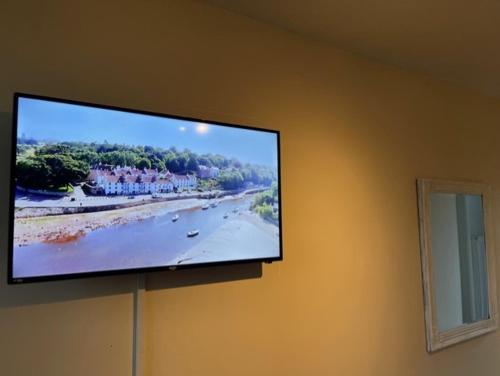 a flat screen tv hanging on a wall at west park hotel chalets in Clydebank