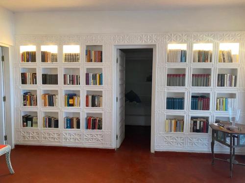 a room with white book shelves filled with books at White Lion in Malindi