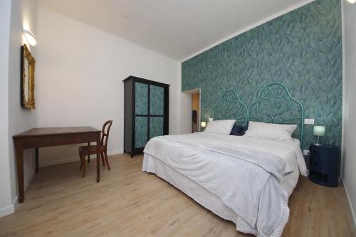 a bedroom with a large bed and a desk at Antinori's House in Perugia