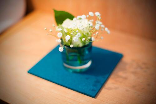 a vase of white flowers sitting on a table at Sebcity Hotel in Ellwangen