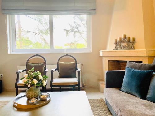 a living room with a couch and two chairs at Marousi Boutique Apartment in Athens