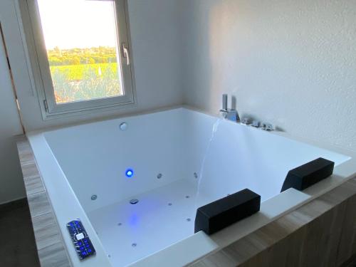 a white bath tub with a window in a bathroom at CASA SUITE JTG in Alicante