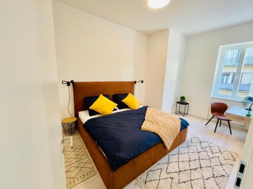 1 dormitorio con 1 cama grande con almohadas amarillas en Dagmar Apartment en Bratislava