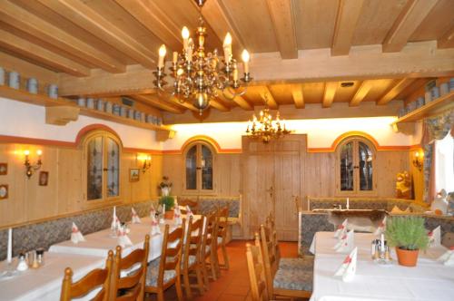 a dining room with tables and chairs and a chandelier at Landgasthof Venushof in Bad Griesbach