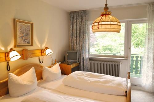 a bedroom with a bed and a window at Landgasthof Venushof in Bad Griesbach