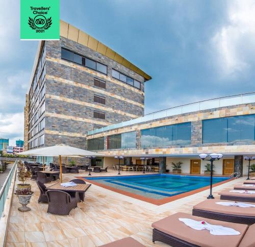 un grand bâtiment avec une piscine devant dans l'établissement CBD Hotel, à Dar es Salaam