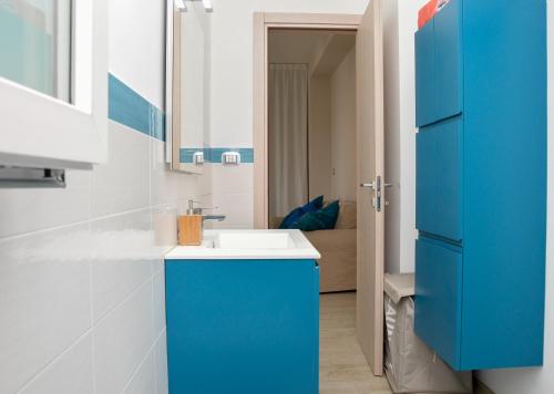 een badkamer met een blauwe kast en een wastafel bij Appartamento le calette in Stazzo