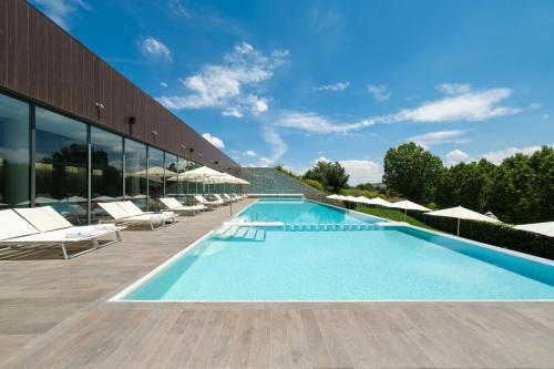 a swimming pool with lounge chairs and a building at Castilla Termal Monasterio de Valbuena in Valbuena de Duero