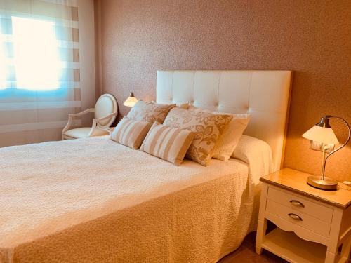 sypialnia z łóżkiem, krzesłem i oknem w obiekcie SANXENXO SUITES CON VISTAS Muy Bien Ubicado w mieście Sanxenxo