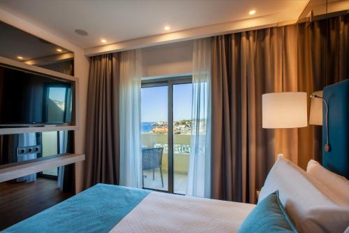 een hotelkamer met een bed en uitzicht op de oceaan bij TURIM Presidente Hotel in Portimão