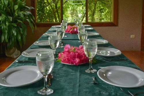 a long table with plates and wine glasses on it at Casa Drake Lodge in Drake