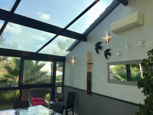 a living room with windows and a table and chairs at L'ESCALE COTE BLEUE B&B AND Spa in Sausset-les-Pins