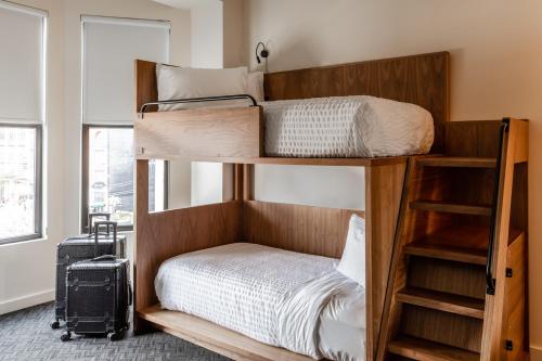 two bunk beds in a room with a suitcase at Found Hotel Chicago River North in Chicago