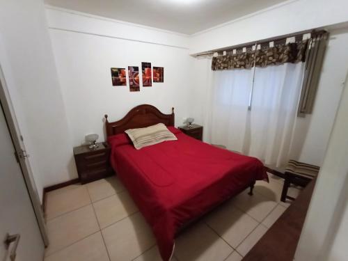 1 dormitorio con cama roja y manta roja en EF Departamentos Plaza Colon Con Cochera en Mar del Plata