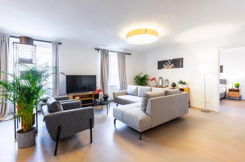 a living room with two couches and a tv at Experience Central Vienna from a Stylish and Modern Apartment in Vienna