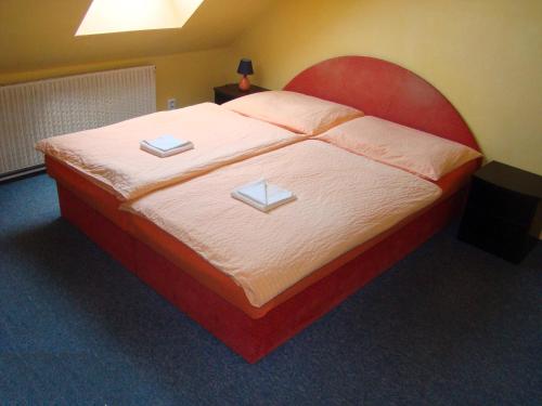 a bedroom with a large bed with two books on it at Restaurace penzion Rafael in Dlouhá Brtnice